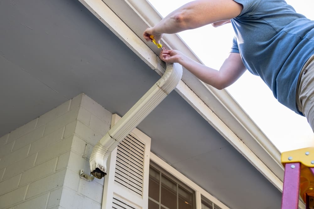 Middle,Aged,White,Woman,Working,Overhead,On,A,Ladder,With